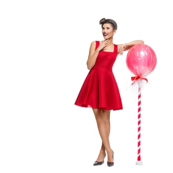 Beautiful young woman in red dress with huge lollipop candy. Surprised expression. Isolated over white background. Copy space. Square composition.