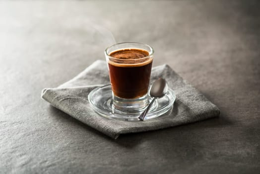 Cup of espresso coffee on dark background.