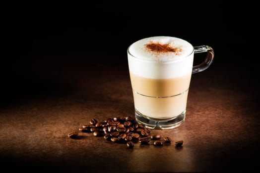 Cup of hot Cappuccino Coffee on dark background.
