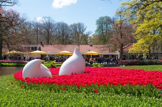 LISSE, NETHERLANDS - APRIL 17, 2016: Art objects in a field of blooming red tulips in the famous Keukenhof Gardens in the netherlands