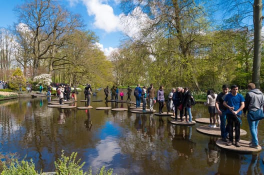 LISSE, NETHERLANDS - APRIL 17, 2016: Unknown tourists enjoying the water route in the famous keukenhof gardens in the netherlands