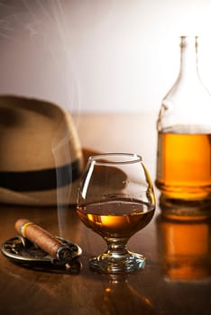 Whiskey, cognac, brandy and cigar on wooden background.