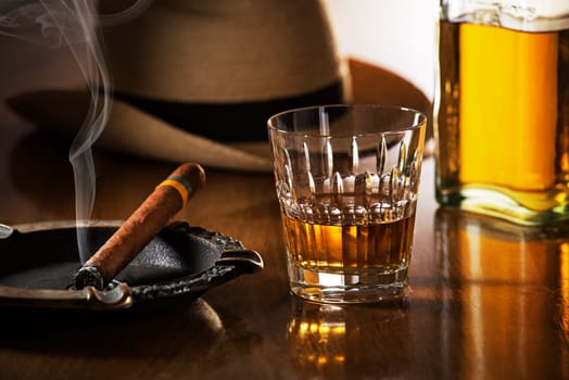 Whiskey and cigar on wooden background close up