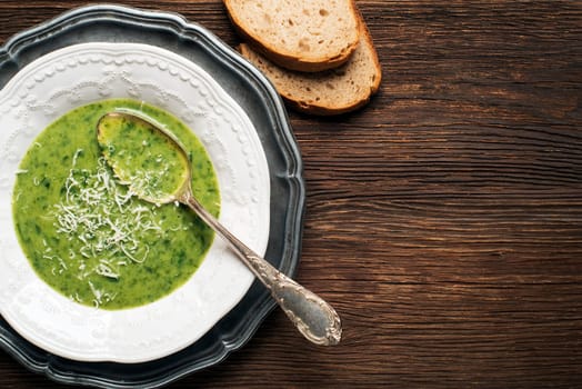 Fresh green soup on wooden background overhead shoot.