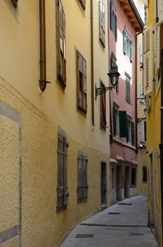 View of old narrow street with colored houses in Trieste, Italy.