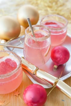 Pink cocktail with sugar rim and grapefruit and Christmas decorations