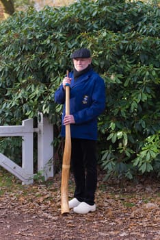 OLDENZAAL, NETHERLANDS - NOVEMBER 27, 2016: Unknown man posing with a so called "midwinterhorn"", a traditional handmade wooden instument. It is used in the advent period in some eastern parts of the netherlands"