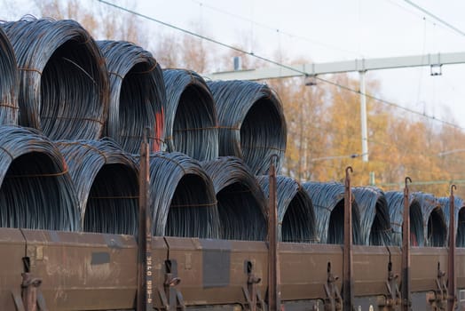 row of train cargo wagons with rolls of steel wire