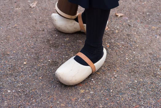 woman legs with a pair of pretty new wooden clogs with leather straps