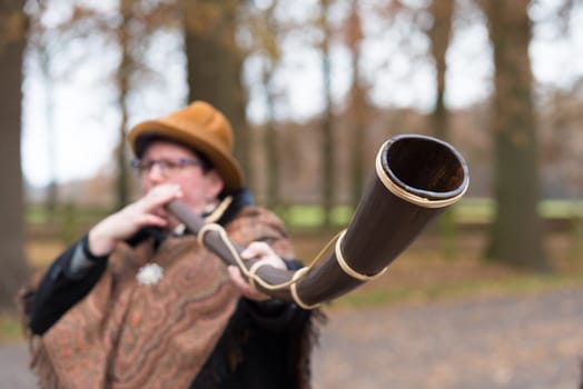 OLDENZAAL, NETHERLANDS - NOVEMBER 27, 2016: Unknown woman blowing a so called "midwinterhorn"", a traditional handmade wooden instument. It is used in the advent period in some eastern parts of the netherlands"