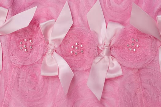 Background of pink satin fabric in the form of roses close-up.