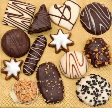 Chocolate candies and cookies on a golden background.
