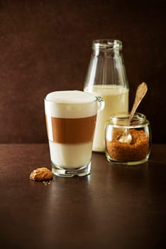 Glass of hot Latte macchiato coffee on dark background