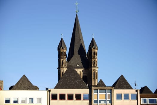 The colorful roofs of the old town in Cologne with the towers of the Groß Sankt Martin Church.