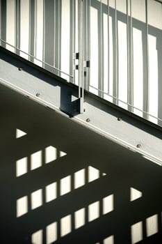 The façade of a residential building with an external staircase that casts a shadow.