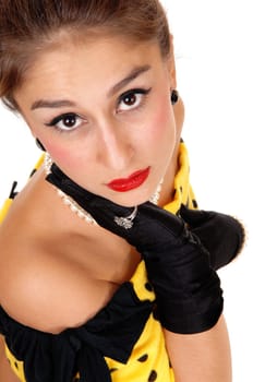 A lovely young woman in a yellow dress and black clover looking very.sad into the camera, isolated for white background..