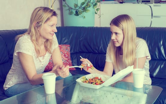 mother and daughter eating together fast food