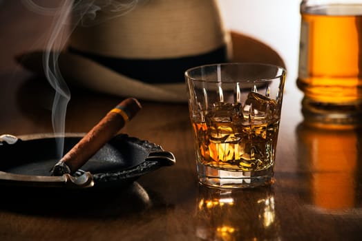 Whiskey and cigar on wooden background close up