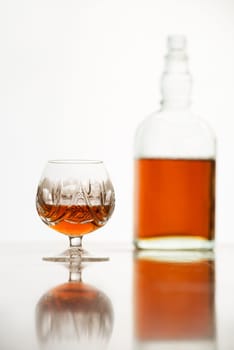 Cognac in glass and bottle on white background
