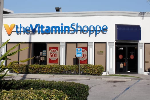 Fort Lauderdale, FL, USA - April 26, 2016: Front of the Vitamin Shoppe retail shop on a sunny day. Facade of the Vitamin Shoppe store with a parking lot in front