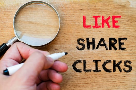 Human hand over wooden background and like share clicks text concept
