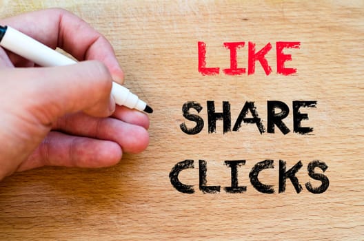 Human hand over wooden background and like share clicks text concept
