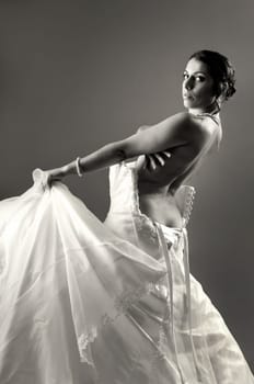 Beautiful bride dressing isolated in a dark background