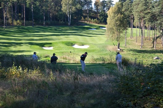 four golf player on hills gollf club have a competition
