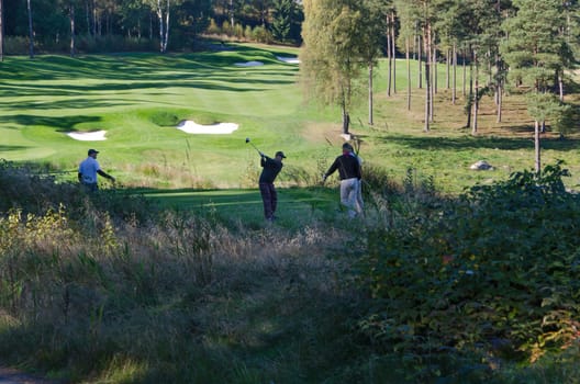 four golf player on hills gollf club have a competition