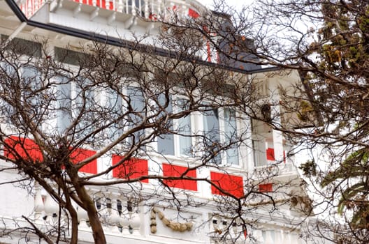 An elegant white house with brilliant red trim looks out over the harbor in Valparaiso, Chile