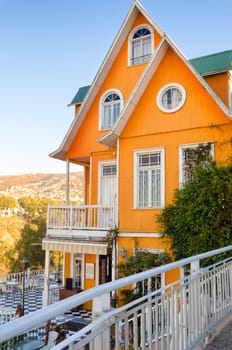 A flash of orange brightens a lofty hillside in Valparaiso, Chile