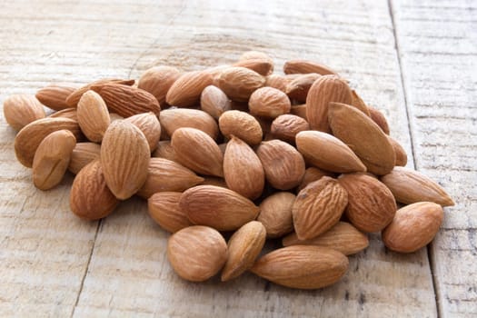 close-up of almonds, piled up  on wooden table