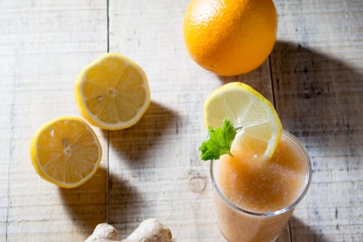 Fresh lemonade with ginger on wooden table with other ingredients for healty snack