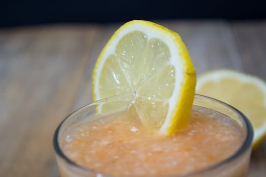 Fresh lemonade with ginger decorated with  lemon on the dark background
