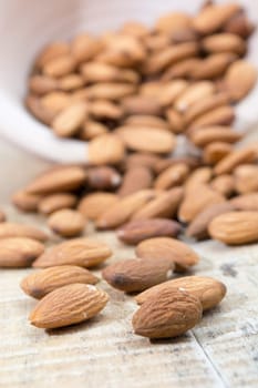 Spilled almonds out of the bowl on the table
