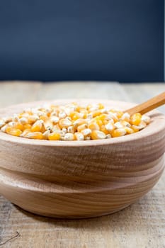 Corn seed in the wooden bowl with the wooden spoon