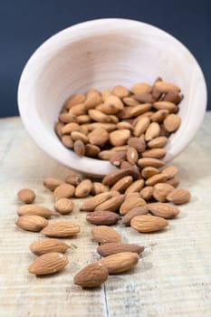 Spilled almonds out of the bowl on the table