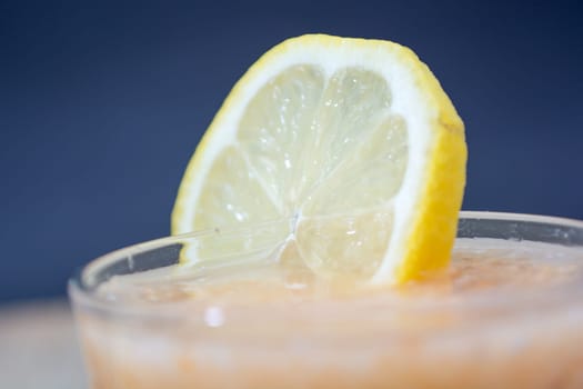 Fresh lemonade with ginger decorated with  lemon on the dark background
