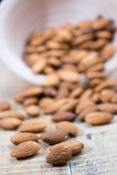 Spilled almonds out of the bowl on the table