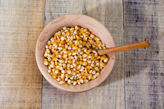 Corn seed in the wooden bowl with the wooden spoon