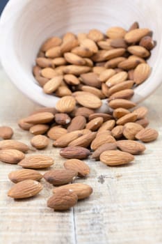 Spilled almonds out of the bowl on the table