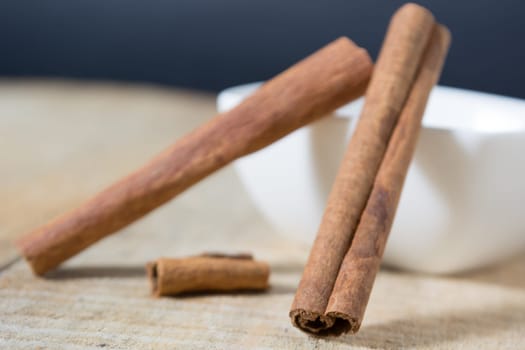 Close up of cinnamon sticks in a white bowl shot with shallow depth of field