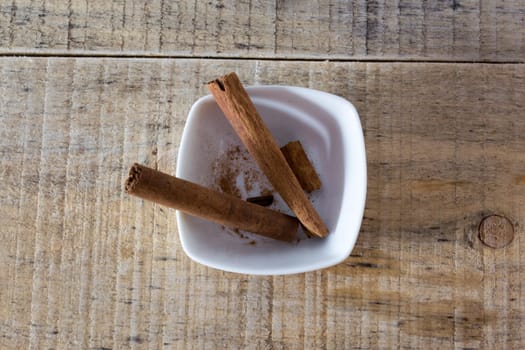 Pair of cinnamon sticks in a white bowl