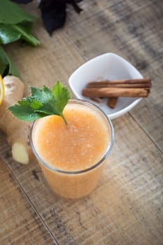 Fresh lemonade with ginger served on a table full with other fruits and cinnamon