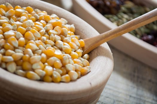Corn seed in the wooden bowl with the wooden spoon