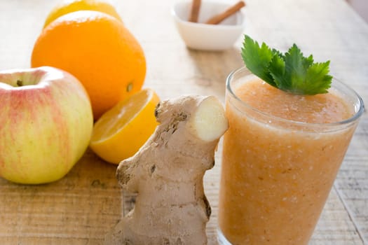 Fresh lemonade with ginger served on a table full with other fruits and cinnamon