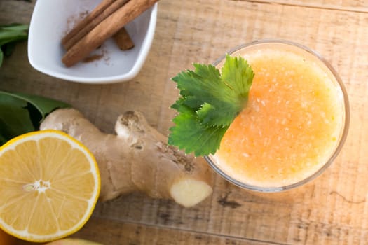 Fresh lemonade with ginger served on a table full with other fruits and cinnamon