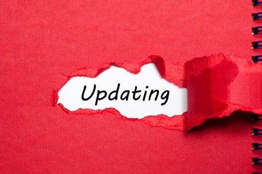 The word updating appearing behind torn paper