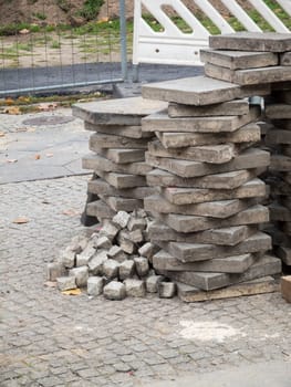 Stacked square pavement slabs on a road construction site.