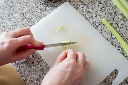 Top view hands cutting with knife celery small